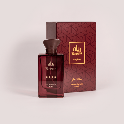 Red perfume bottle with gold text and matching box on a light gray background