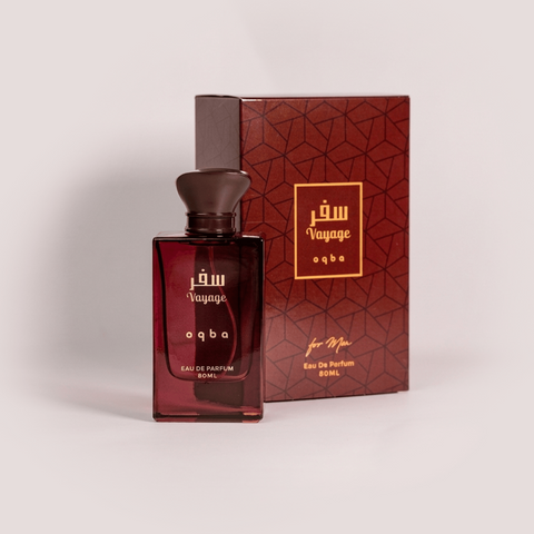Red perfume bottle and packaging with 'Voyage' branding on a light gray background